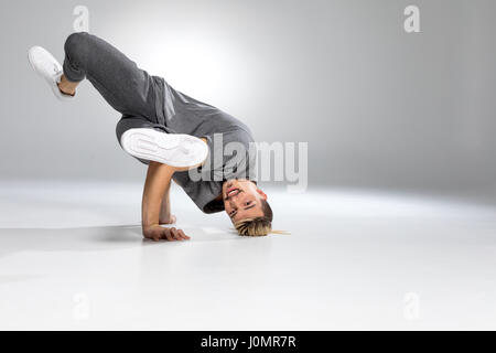 Junge hübsche Breakdance tanzen auf weiß und lächelnd Stockfoto