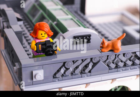 Tambow, Russische Föderation - 21. Januar 2017 Lego Mädchen mit Kamera nehmen Foto vom Dach. Rote Katze sitzt auf dem Geländer. Studio gedreht. Stockfoto