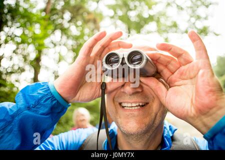 Reifer mann Blick durch ein Fernglas. Stockfoto