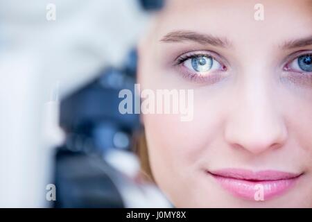 Frau sitzt vor der Schlitz-Lampe für Augenuntersuchung. Stockfoto