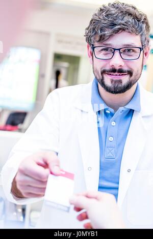 Optiker Übergabe Quittung an Frau. Stockfoto