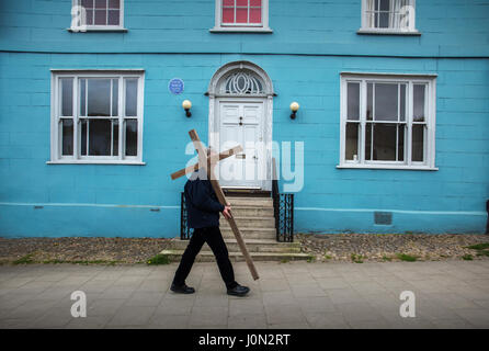 Thaxted, Essex, England. 14. April 2017. Ostern Karfreitag Thaxted Essex UK.14 April 2017 Daniel Fox trägt Christian Cross des Opfers während einer Prozession durch die schönen North West Essex Stadt Thaxted am Karfreitag Ostern Morgen. Übergeben das Haus, wo Gustav Holst Bestandteil der Planeten-Suite schrieb. Wikipeadia unten: "Thaxted" ist eine Hymne Melodie des englischen Komponisten Gustav Holst, basierend auf dem stattlichen Thema aus dem mittleren Abschnitt des Warenverkehrs Jupiter seine Orchestersuite The Planets und Namensgeber Thaxted, die englischen Dorf, wo er viel lebte, seines Lebens. Er passte die Stockfoto