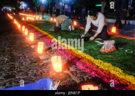 Gemeindemitglieder aus der Escuela de Cristo Kirche verbreiten Blütenblätter um einen 'Alfombra' oder Teppich, als Bestandteil der jährlichen Karwoche in Antigua, Guatemala am 14. April 2017 zu erstellen. Stockfoto