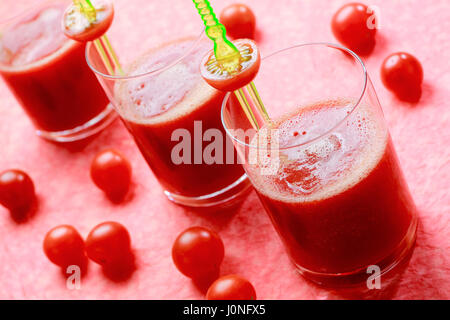 Drei Gläser mit frischem Tomatensaft mit Cherry-Tomaten. Konzentrieren Sie sich auf erste Glas. Stockfoto