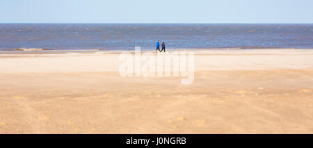 Menschen zu Fuß entlang Holkham Beach, einem riesigen Sandstrand auf die Küste von North Norfolk UK Stockfoto