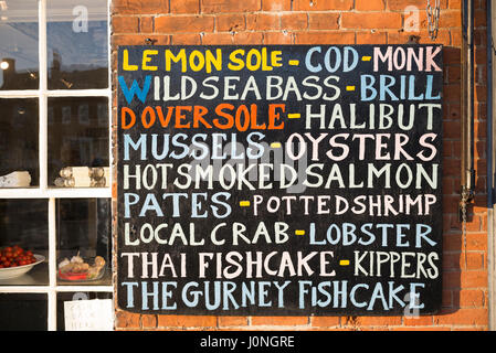 Zeichen - Muscheln, Austern, Lachs, Garnelen, Hummer, Kabeljau, Brill, Seezunge, zum Verkauf an Gurneys Fischgeschäft, Burnham Market, Norfolk, Großbritannien Stockfoto