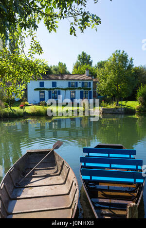 Ruderboote und House Fluss La Sevre-Niortaise in Coulon in Marais Poitrevin Region, Grand Site de France Stockfoto