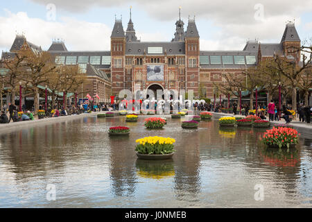 Vorderseite des Rijksmuseums, mit Tulpen im See vor. Amsterdam, Niederlande, Europa. Stockfoto