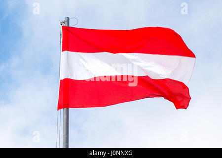 Flagge von Österreich winken in sonnigen und wolkigen Himmel Stockfoto