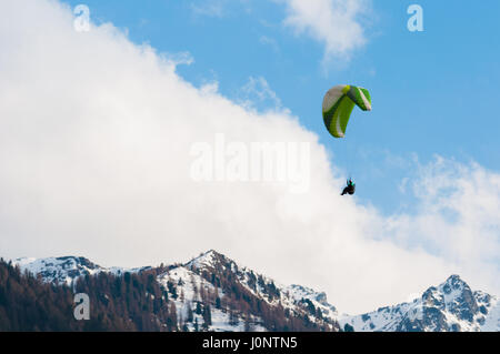 Gleitschirm fliegen in den blauen Himmel zwischen den Wolken und über die Berge Stockfoto