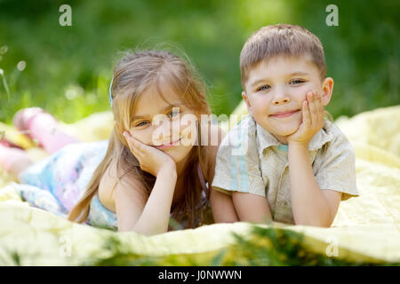 netten jungen und Mädchen auf der Decke liegen Stockfoto