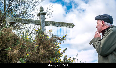 Alter Mann mit Bart über ungewöhnliche Zeichen mit Untertitel verwirrt Suchen hin und wieder zurück, Untertitel Der Hobbit von JRR Tolkien, Schottland, Großbritannien Stockfoto