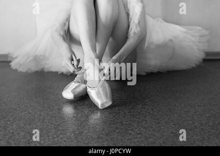 Ballerina setzt auf Spitzenschuhen. Lange schlanke weibliche Füße. Stockfoto