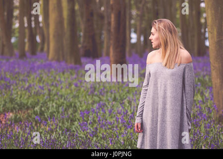 Blonde Frau in einem Bluebell Holz, Wiltshire Stockfoto