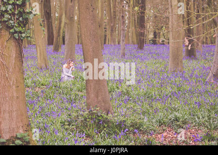 Blonde Frau in einem Bluebell Holz, Wiltshire Stockfoto