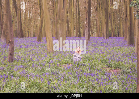 Blonde Frau in einem Bluebell Holz, Wiltshire Stockfoto