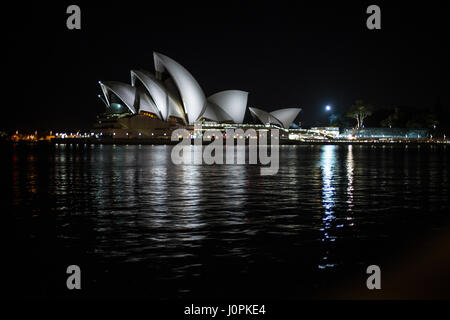 Das Sydney Opera House als von den Felsen gesehen bei Nacht beleuchtet. Stockfoto