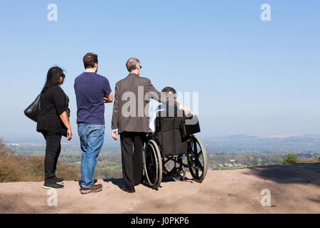 Familie Sightseeing mit einer Person in einem Rollstuhl genießen Sie den Blick / Szene / Landschaft in Cheshire Plain / Flachland tagsüber, an Alderley Edge, UK. Stockfoto