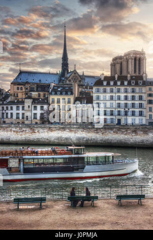 Zwei Mädchen auf dem Quai de l'Hôtel de Ville und touristischen Schiff, mit Blick auf die Quai Bourbon und Notre-Dame. Frankreich. Paris Stockfoto