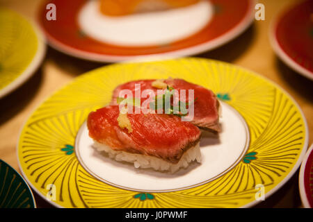 Bewusste Konzentration auf seltene Filet Mignon Tataki Rindfleisch Nigiri Sushi auf einem Teller mit geringen Schärfentiefe für Hintergrundeffekt. Gyuuniku Rindfleisch ist ligh Stockfoto