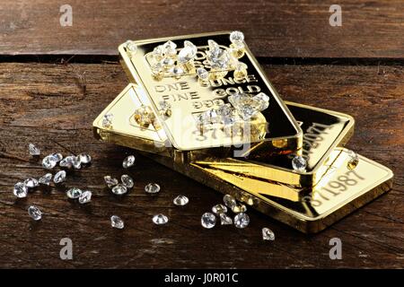 Goldbarren und Diamanten auf hölzernen Hintergrund Stockfoto