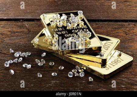 Goldbarren und Diamanten auf hölzernen Hintergrund Stockfoto