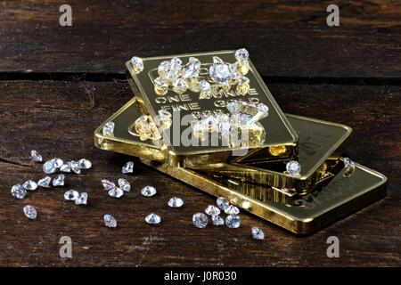 Goldbarren und Diamanten auf hölzernen Hintergrund Stockfoto