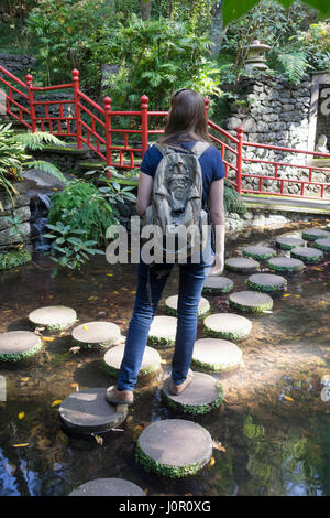 Ein Tourist macht ihren Weg über Trittsteine in Monte Palace Tropical Garden, Funchal Stockfoto