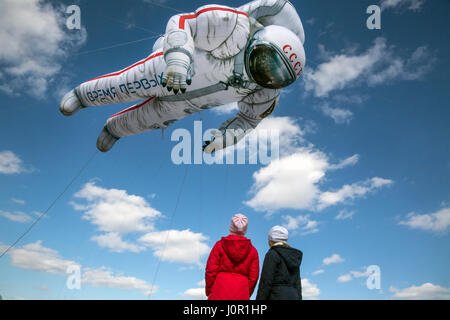 Mädchen schauen einen Ballon in Form eines sowjetischen Kosmonauten, die fliegen in der Nähe von Einkaufszentrum in Moskau, Russland Stockfoto