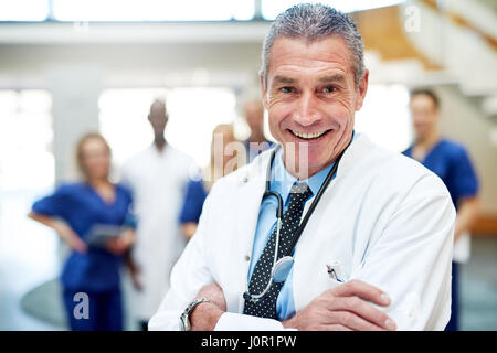 Porträt von fröhlichen Arzt in einem Krankenhaus steht mit Armen gekreuzt. Stockfoto