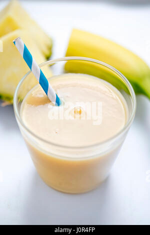 Pina-Colada Ananas-Bananen-Smoothie mit blauen Stroh Stockfoto