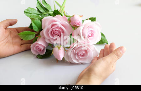 Wunderbare Ton Kunst, Frau Hand halten Strauß Rosen Blumen in Rosa auf weißem Hintergrund, schöne künstliche Blumen von Handwerkskunst mit geschickten Stockfoto