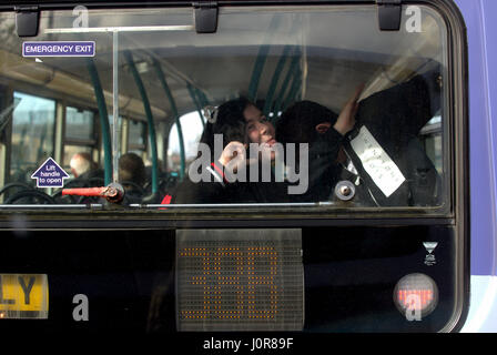 Kinder über grimassen an der Rückseite eines Busses messing Tupfen Stockfoto