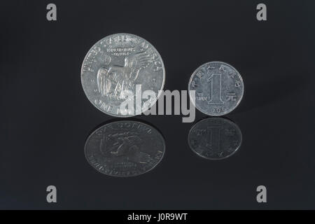 1 Yuan / US $1-Dollar-Münze auf dunklem Hintergrund - Metapher für den Dollar / US-Dollar/Yuan-Wechselkurs / wall street / financial Markets. Stockfoto