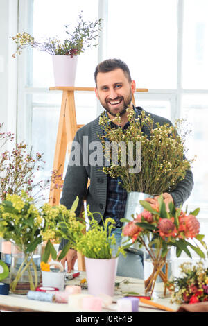 Blumengeschäft am Arbeitsplatz: der junge Mann macht Mode moderne Blumenstrauß verschiedene Stockfoto