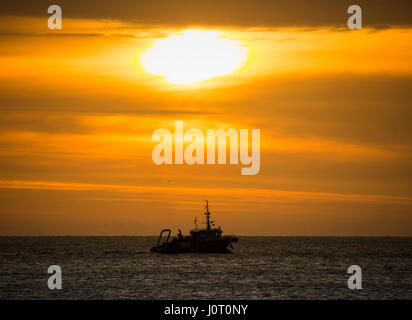 Seaton Carew, County Durham, England. VEREINIGTES KÖNIGREICH. 16. April 2017. Wetter: Ein Fischerboot Segel aus Hartlepool bei Sonnenaufgang an einem kalten Ostersonntag an der nordöstlichen Küste. Bildnachweis: ALAN DAWSON/Alamy Live-Nachrichten Stockfoto