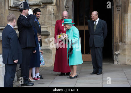 Windsor, UK. 16. April 2017. Vorlegen Sie zwei junge Mädchen, Eowyn Bannan, 6, und Josephine Thompson, 5, die Königin Blumensträuße Blumen, als sie den Ostersonntag Dienst am St. George Chapel in Windsor Castle, begleitet von der Duke of Edinburgh verlässt. Bildnachweis: Mark Kerrison/Alamy Live-Nachrichten Stockfoto