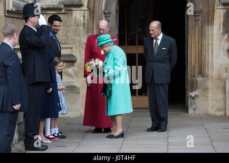 Windsor, UK. 16. April 2017. Vorlegen Sie zwei junge Mädchen, Eowyn Bannan, 6, und Josephine Thompson, 5, die Königin Blumensträuße Blumen, als sie den Ostersonntag Dienst am St. George Chapel in Windsor Castle, begleitet von der Duke of Edinburgh verlässt. Bildnachweis: Mark Kerrison/Alamy Live-Nachrichten Stockfoto