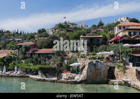 SIMENA, Türkei - 20.Mai: Kalekoy Simena Siedlung in der Uchagiz Bucht der Türkei in der Nähe von versunkenen Stadt Kekova mit Stonebuilt Häusern mit alten Ruine gemischt Stockfoto