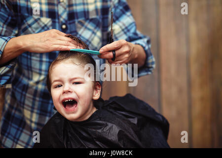 Ein kleiner Junge ist in der Friseur getrimmt Stockfoto