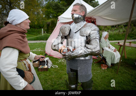 Ein Ritter wird geholfen, in seiner Rüstung in Vorbereitung auf eine Schlacht am Glastonbury mittelalterlichen Wochenende an die Abtei von Glastonbury in Somerset zu kleiden. Stockfoto