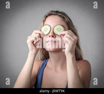 Frau mit Gurke auf ihre Augen Stockfoto