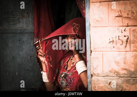 Asiatische Dame späht heraus unter ihrem Schleier, blaue Stadt, Jodhpur, Rajasthan, Indien Stockfoto