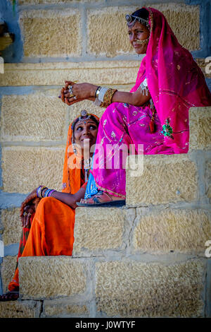 2 indische Damen sitzen auf Schritte im Chat in traditioneller Kleidung von Rajasthan Stockfoto