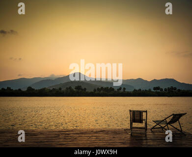 tropischen exotischen am Flussufer Blick auf den Sonnenuntergang in Kampot Kambodscha Asien mit Liegestühlen Stockfoto