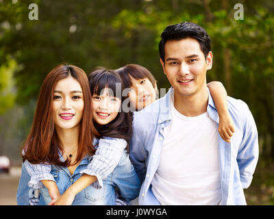 glückliche asiatischen Familie mit zwei Kindern, die bei einem Spaziergang im Park mit Bäumen. Stockfoto