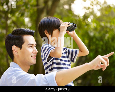 asiatischen Vater und Sohn mit dem Fernglas im park Stockfoto