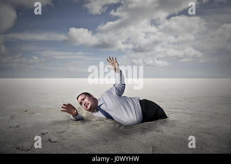 Fett Geschäftsmann im Sand versinken Stockfoto