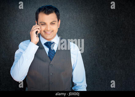 Closeup Portrait, hübscher junger Geschäftsmann, glücklicher Kerl, Weste und Krawatte, mit Handy, lächelnd, isoliert angenehmes Gespräch, grau blac Stockfoto