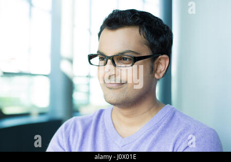 Closeup Kopfschuss Portrait, glücklich gut aussehend Geschäftsmann, schwarze Brille, auf der Suche nach seitwärts, in Office-Hintergrund isoliert. Stockfoto